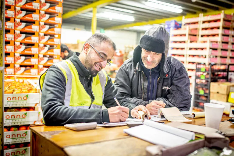 Two market operatives completing paperwork