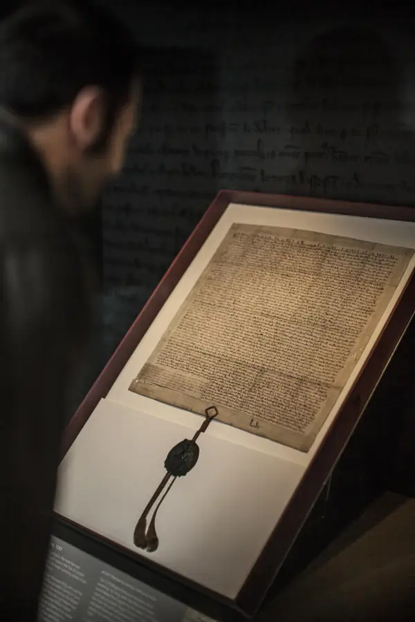 A visitor examining a copy of the Magna Carta at the Heritage Gallery