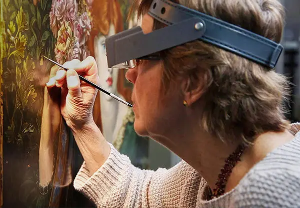 woman retouching leaves on a painting