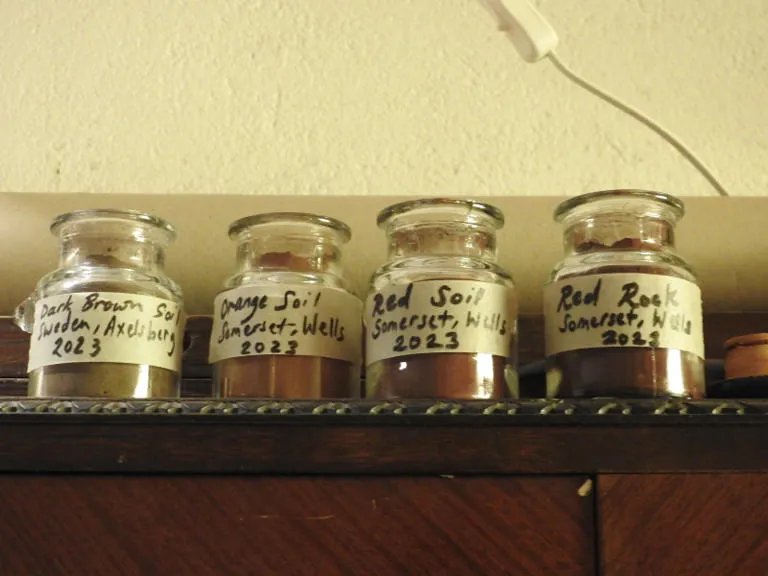 Four jars of soli with labels on a shelf