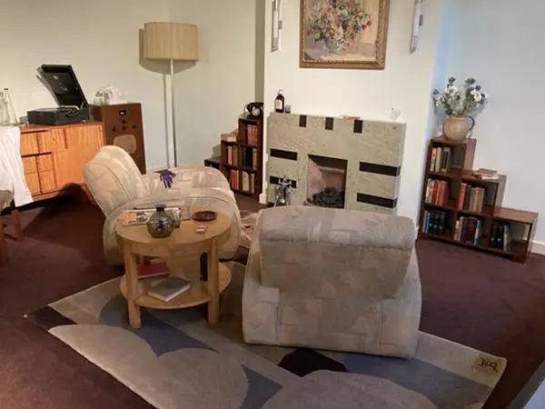 Betty Joel Ltd Rug, with monogram in corner, and bookcases in a 1930s period living room at the Museum of the Home