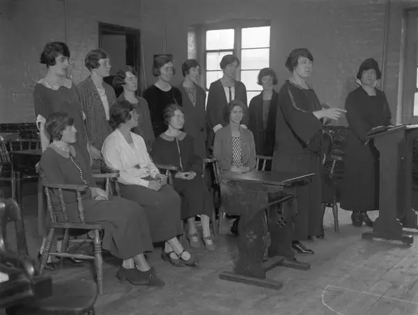 A group of young females, sitting in a classroom, being tutored in oration, 1924 
