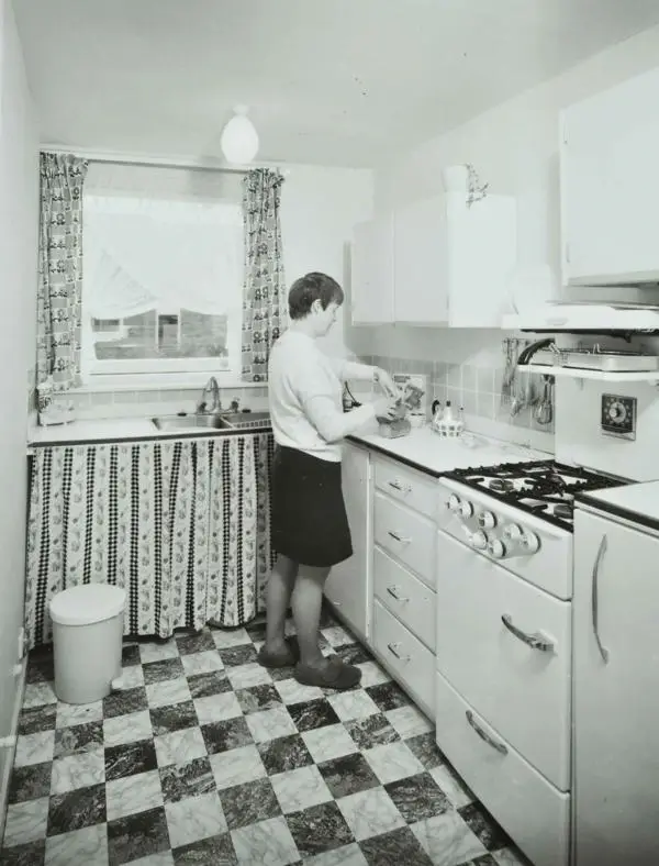 Woman standing in the kitchen at an Andover Town Development, 1969