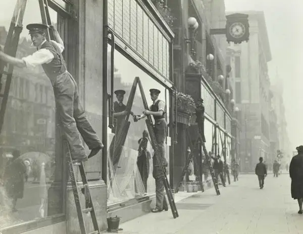 Window cleaners on ladders, cleaning at Peter Robinson's department store