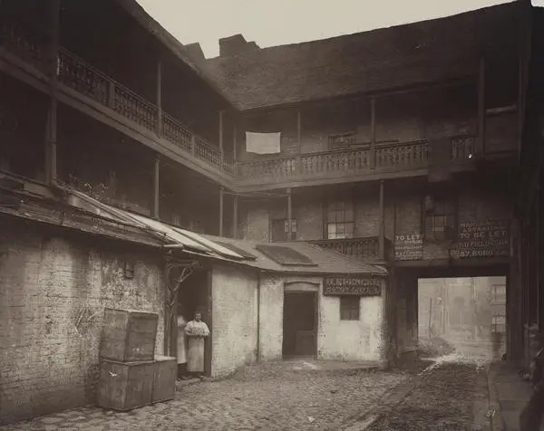 View of the White Hart Inn yard, Southwark, 1881. Two figures can also be seen standing in a doorway.
