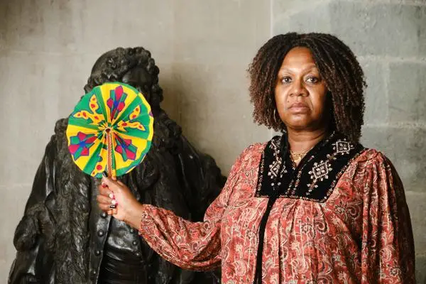 Gloria covering up Cass' statue with a West African fan