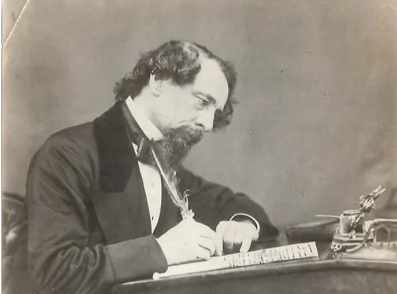Charles Dickens writing at his desk